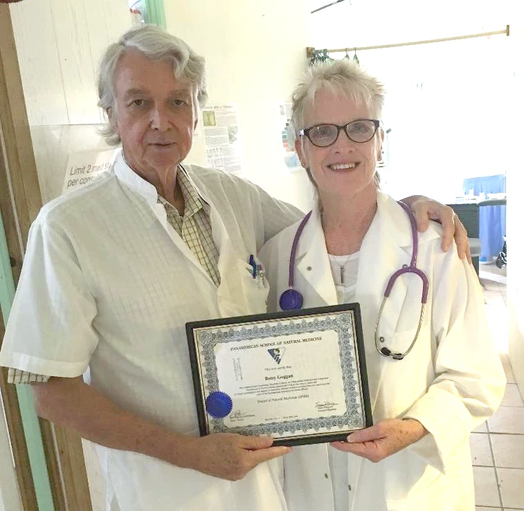 Dr. Betsy Goggan, Naturopathic Doctor, holding her diploma from the Pan-American School of Natural Medicine alongside a colleague, celebrating her commitment to holistic health and whole-body healing.